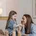 A loving mother and daughter enjoying quality time together in a cozy kitchen setting.