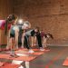Fitness group performing exercises with dumbbells in a modern yoga studio setting.